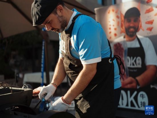 7月19日，在蕪湖古城，馬丁在當天舉行的啤酒節(jié)上制作牛排。新華社發(fā)（繆雨晨 攝）