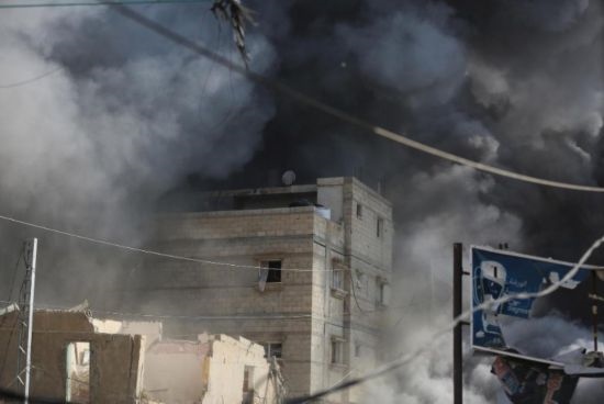 7月21日，在加沙地帶中部的努賽賴特難民營，遭以軍空襲的建筑冒出滾滾濃煙。新華社發(fā)（馬爾萬·達(dá)烏德攝）