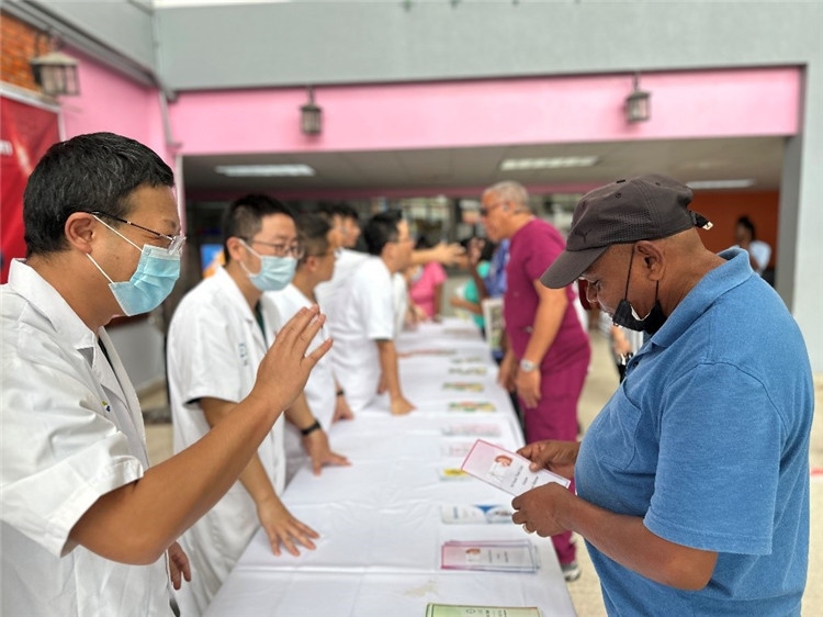 援圭醫(yī)療隊隊員們在啟動儀式上為當?shù)孛癖姺职l(fā)宣傳手冊。中國援助圭亞那醫(yī)療隊供圖