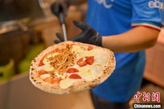 近日，韋榮耀展示他制作的“老友味”披薩。 俞靖 攝
