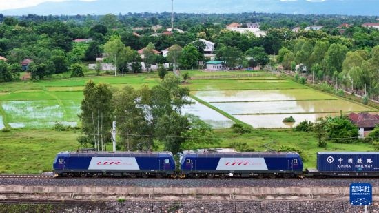 8月5日，由老撾籍火車司機(jī)獨(dú)立駕駛的滿載貨物的列車駛出萬象站，向中國昆明進(jìn)發(fā)（無人機(jī)照片）。新華社發(fā)（楊永全 攝）