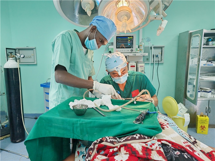 李廣醫(yī)生與當?shù)蒯t(yī)生在做手術中。中國援桑醫(yī)療隊供圖