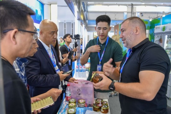 2023年8月23日，在第十四屆中國(guó)—東北亞博覽會(huì)東北亞商品館，俄羅斯參展商向參觀者介紹商品。