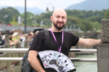 俄羅斯塔斯社執(zhí)行編輯葉夫根尼·扎多羅日內(nèi)在都江堰魚嘴拍照留念。（李佩藺 攝）