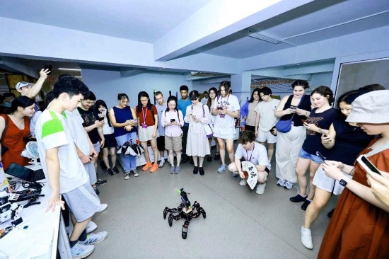 8月25日，中外青年在浙江杭州觀看機器人表演。新華社發(fā)（清華大學供圖）
