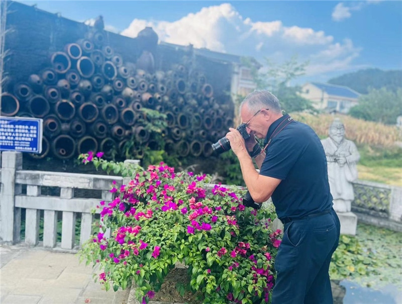 遠(yuǎn)處黔北民居錯(cuò)落有致，近處一只黑色的蝴蝶穿梭于粉紫色三角梅花叢間隙，與俄羅斯“大歐亞”總編輯弗拉基米爾·別列日內(nèi)赫的鏡頭玩起了捉迷藏，“你追我逃，不亦樂(lè)乎”。（張亞欣攝）