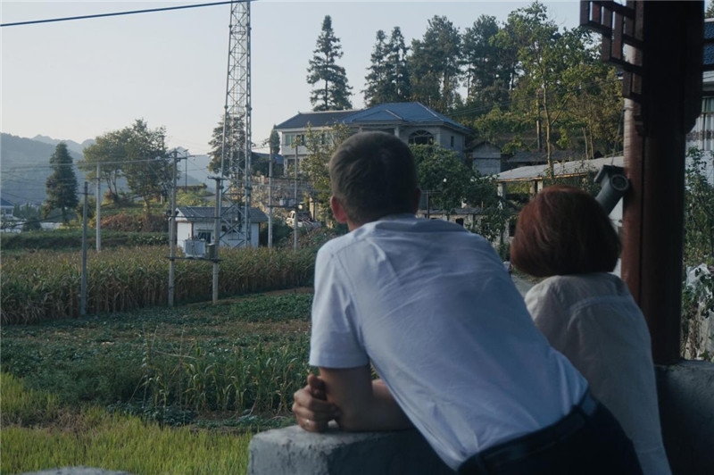 望得見(jiàn)山，看得見(jiàn)水，記得住鄉(xiāng)愁。每個(gè)人心中都有一個(gè)屬于自己的“花茂村”，在這方心田，走遍千山萬(wàn)水，鄉(xiāng)音未改鬢毛衰。吉爾吉斯斯坦《比什凱克晚報(bào)》第一副總編輯妮娜·尼奇博洛娃與《中國(guó)與俄羅斯》雜志社社長(zhǎng)奧列格·別列日內(nèi)赫攝在花茂村民居屋檐下并肩佇立，眺望山水，尋覓鄉(xiāng)愁。（李光裕攝）