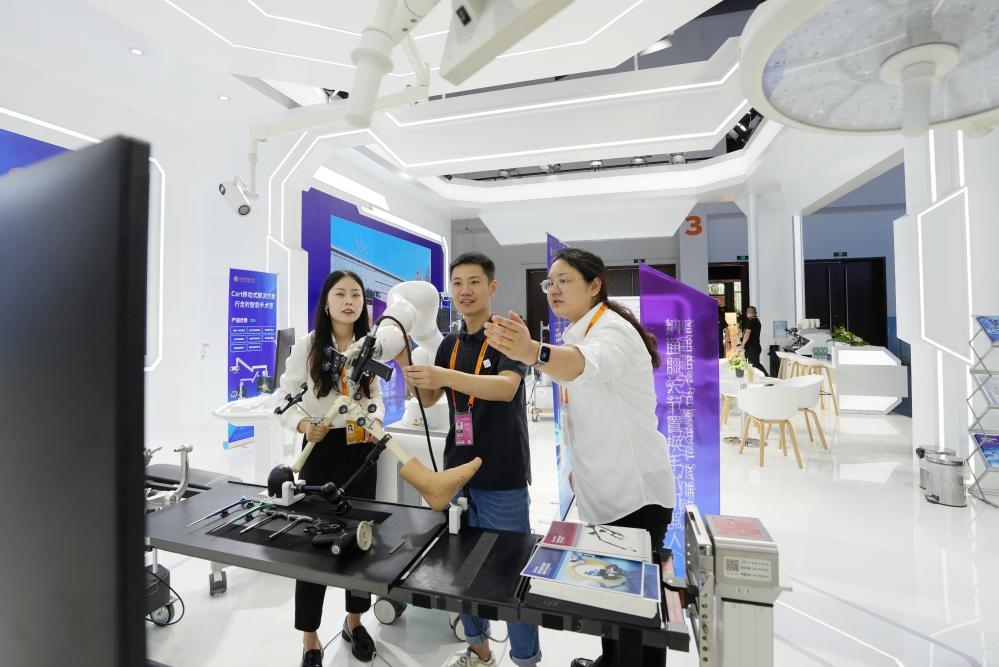 9月11日，一位媒體記者（中）在2024年服貿會國家會議中心會場體驗北京納通科技集團有限公司的膝關節(jié)置換手術機器人。新華社記者鞠煥宗 攝