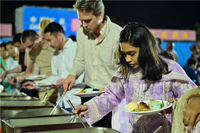 外國(guó)友人品嘗中國(guó)美食。馬騫攝