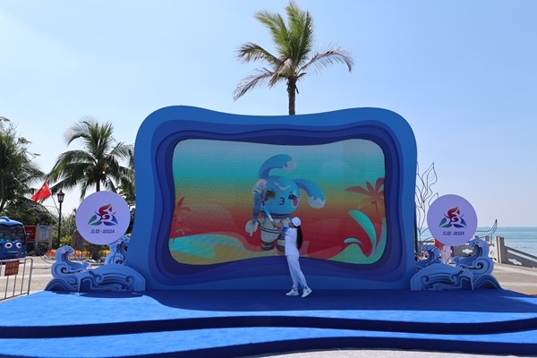 第12棒火炬手“點燃”現(xiàn)場大屏幕上運(yùn)動會吉祥物“吉貝”手中的火炬。主辦方供圖