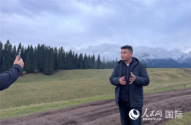 在庫爾德寧，吾買爾江被雪山美景震撼，即興錄制了短視頻作品。人民網(wǎng)記者曾書柔攝