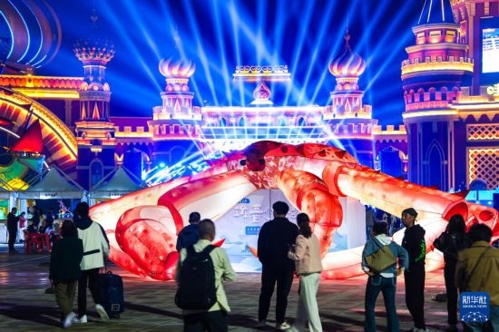 9月19日，游客在吉林省琿春市的2024琿春帝王蟹美食嘉年華現(xiàn)場(chǎng)游玩。新華社記者 許暢 攝