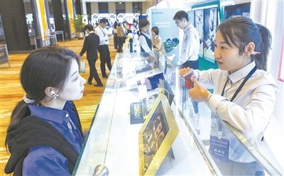 在北京麗澤商務(wù)區(qū)，工作人員（右一）介紹數(shù)字人民幣SIM卡硬錢包。新京報(bào)記者 陶冉攝