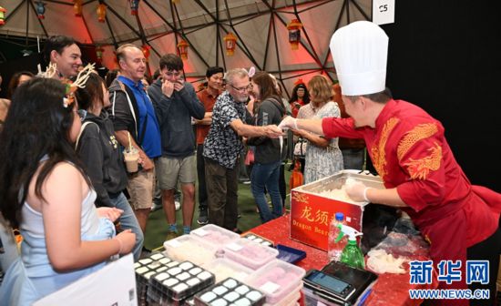 圖為游客在燈節(jié)現(xiàn)場購買小吃。（圖片由奧克蘭中國文化中心提供）