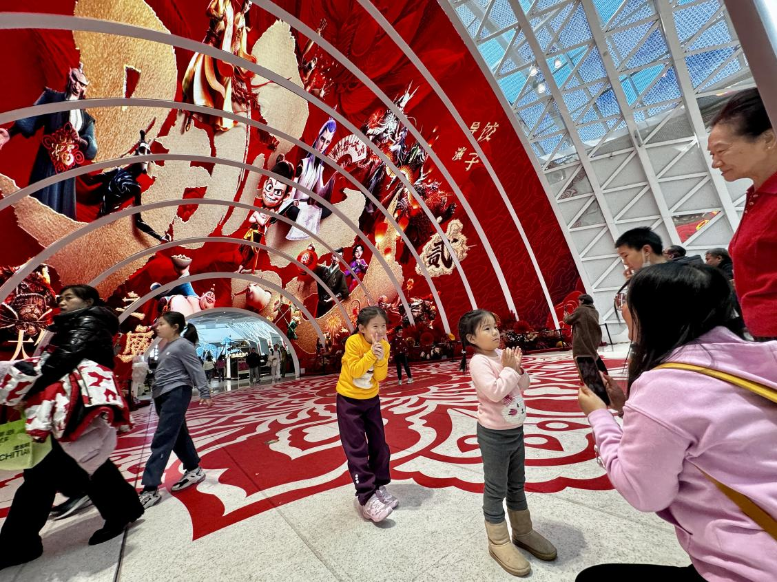 乙巳蛇年春節(jié)期間，影迷在《哪吒之魔童鬧海》巨幅海報前拍照打卡。