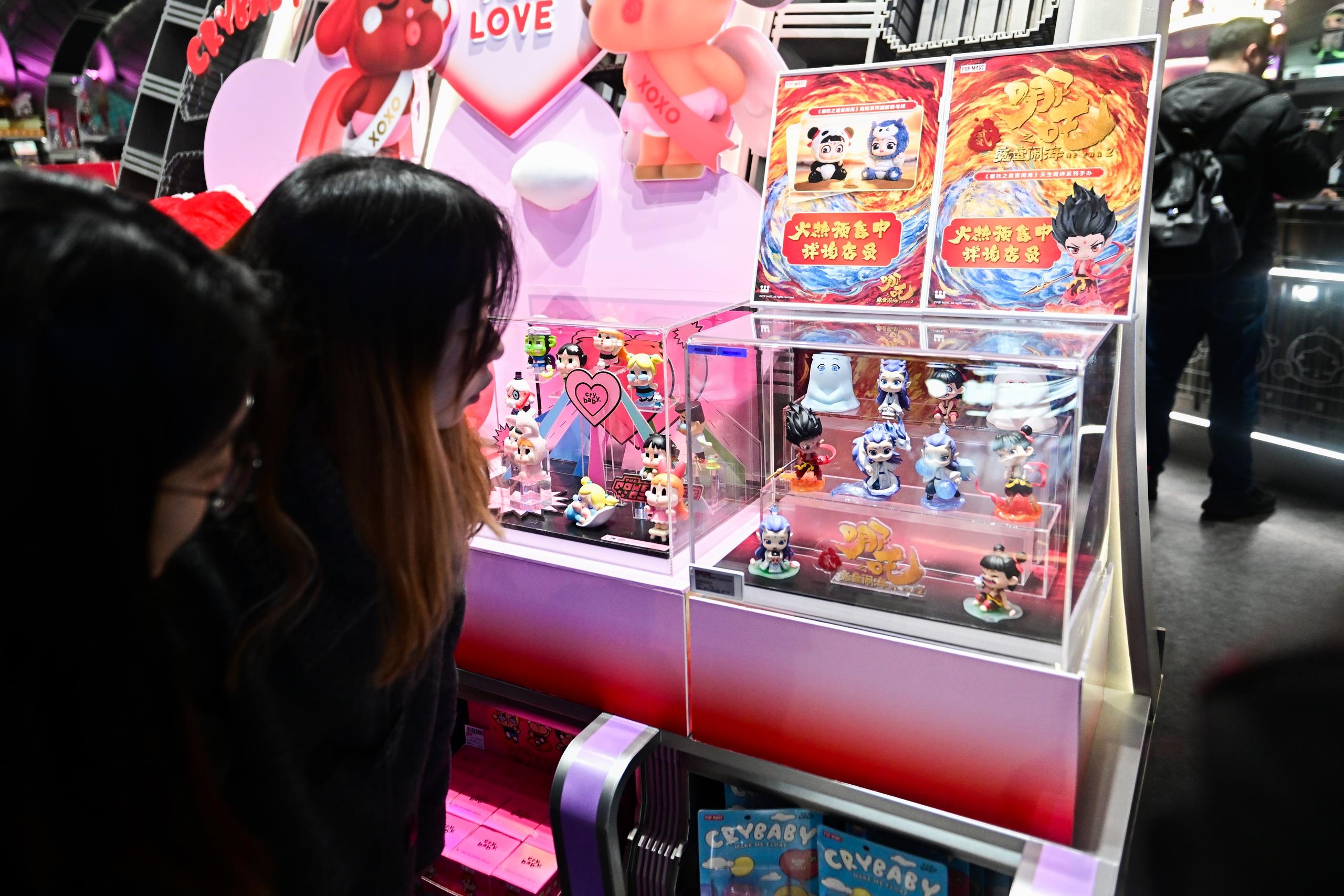 △2025年2月22日，上海，市民在圍觀《哪吒之魔童鬧?！废嚓P(guān)手辦盲盒。