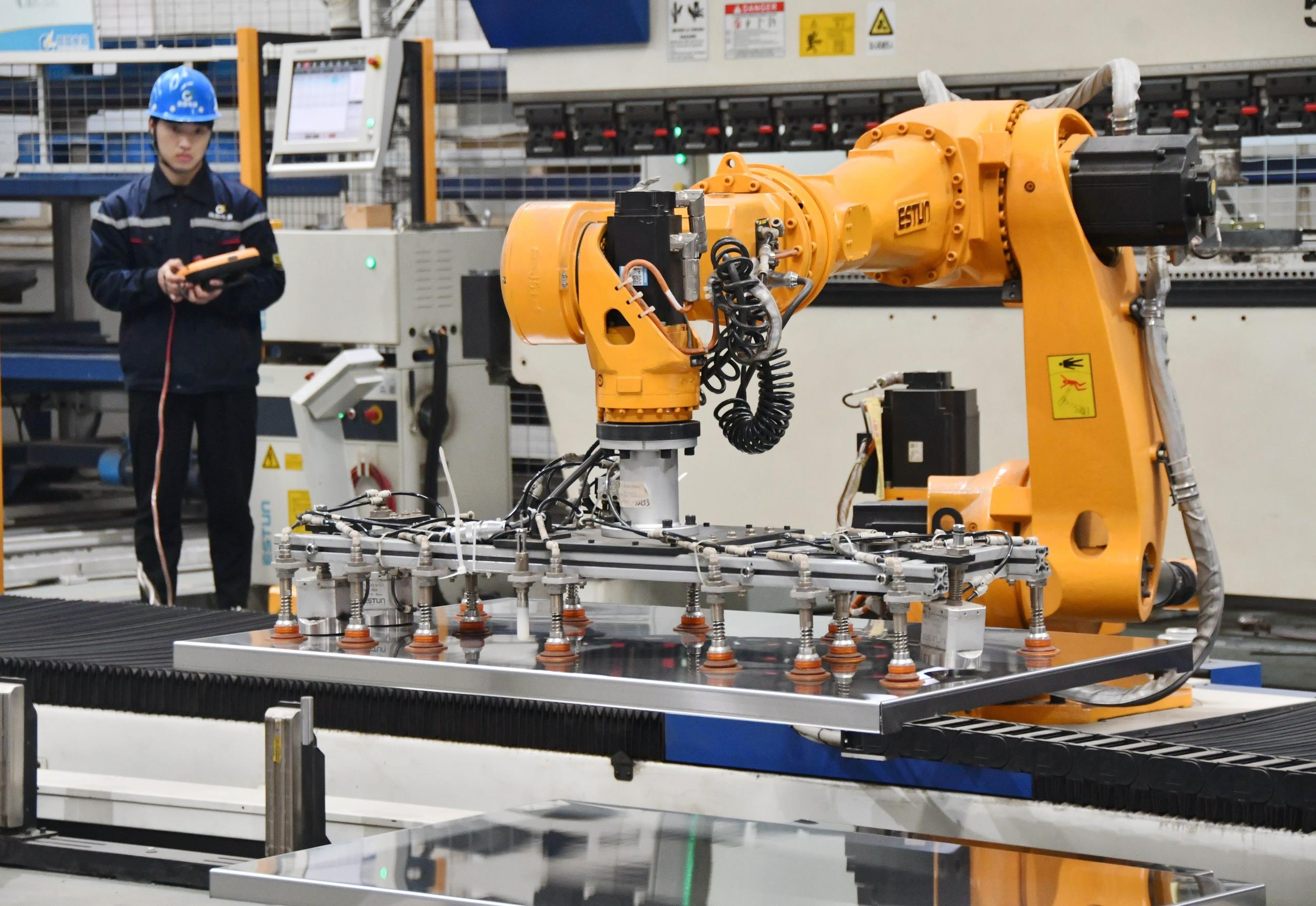 △2025年2月21日，河北邯鄲永年區(qū)工業(yè)園區(qū)的一家企業(yè)，工人正在操控工業(yè)機(jī)器人作業(yè)。