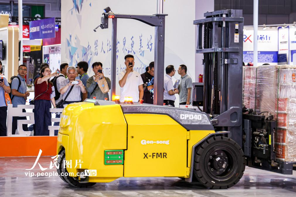 第24屆中國(guó)工博會(huì)現(xiàn)場(chǎng)，觀眾觀看叉取機(jī)器人作業(yè)演示。王初攝（人民圖片網(wǎng)）