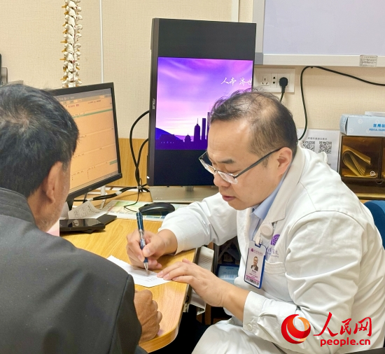 路桂軍接診時(shí)為患者寫(xiě)下用藥提示。人民網(wǎng)記者 金慧慧攝