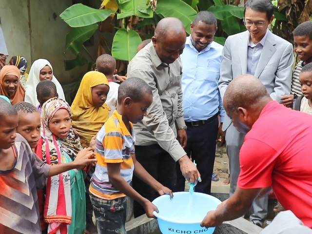 在日前舉行的安全供水工程揭牌儀式上，當(dāng)?shù)匦∨笥言诠┧c(diǎn)接水。 施亮攝