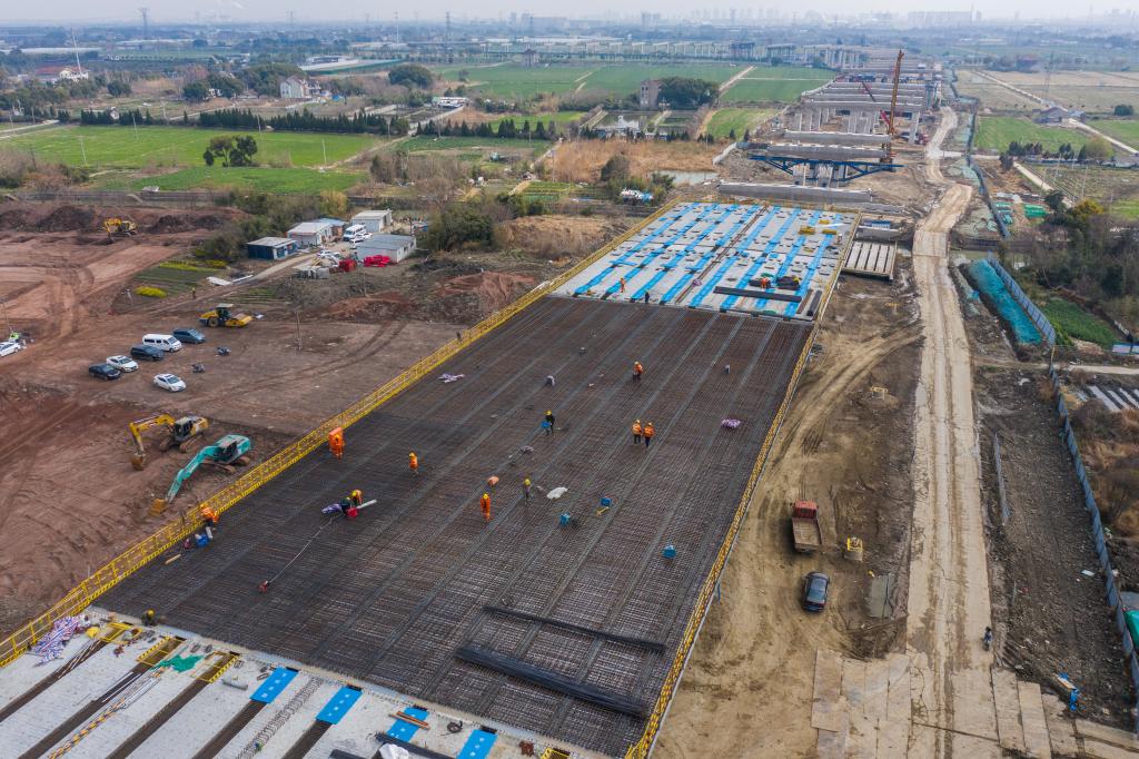 3月7日，在524國(guó)道秀洲王江涇至新塍公路工程TJ02標(biāo)段，作業(yè)人員正在進(jìn)行60米鋼混組合梁現(xiàn)澆橋面板鋼筋焊接及綁扎作業(yè)（無人機(jī)照片）。新華社記者 徐昱 攝