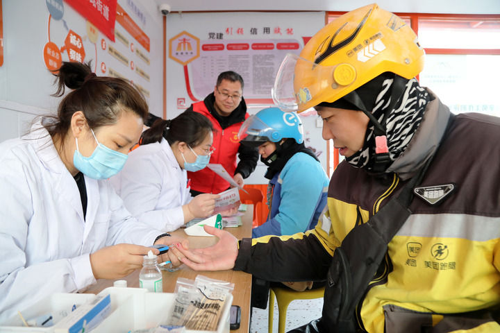 2025年3月5日，志愿者在山東省棗莊市市中區(qū)一工會驛站為外賣員免費測量血糖。新華社發(fā)（王海楠攝）