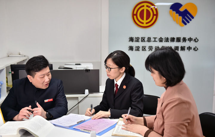 2025年3月6日，在北京市海淀區(qū)總工會勞動爭議調(diào)解中心，海淀區(qū)人民法院法官王琰（中）與該中心工作人員就糾紛化解情況進行溝通。新華社記者 趙婷婷 攝