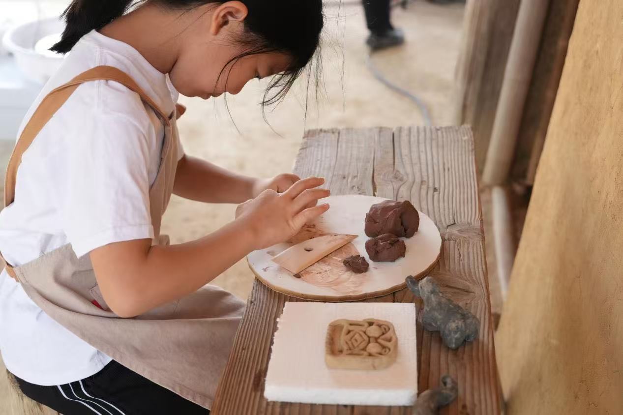 游客制作良渚特色陶藝品。良渚博物院供圖