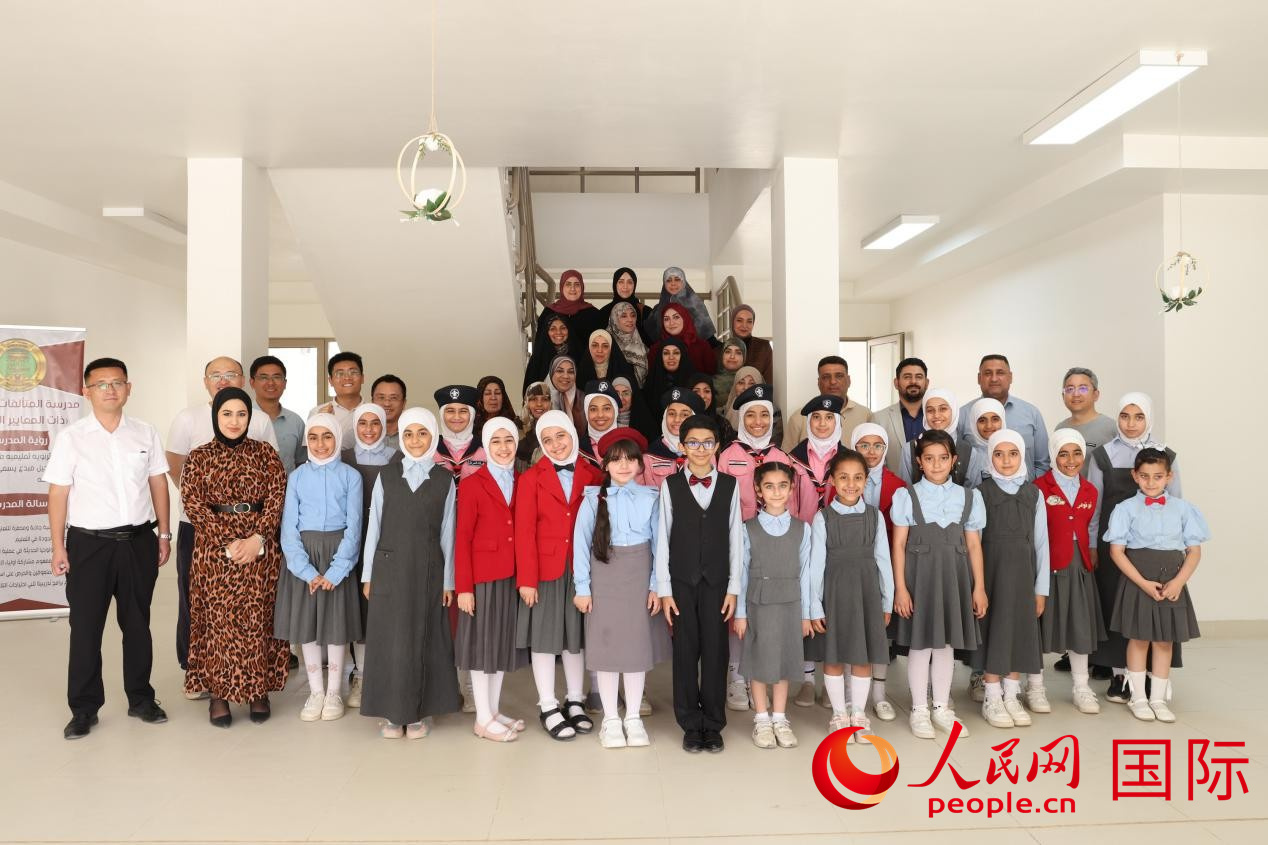 中國電建員工與阿爾穆塔?阿里卡特國際學(xué)校的師生及政府官員等合影。人民網(wǎng)記者 薛丹攝