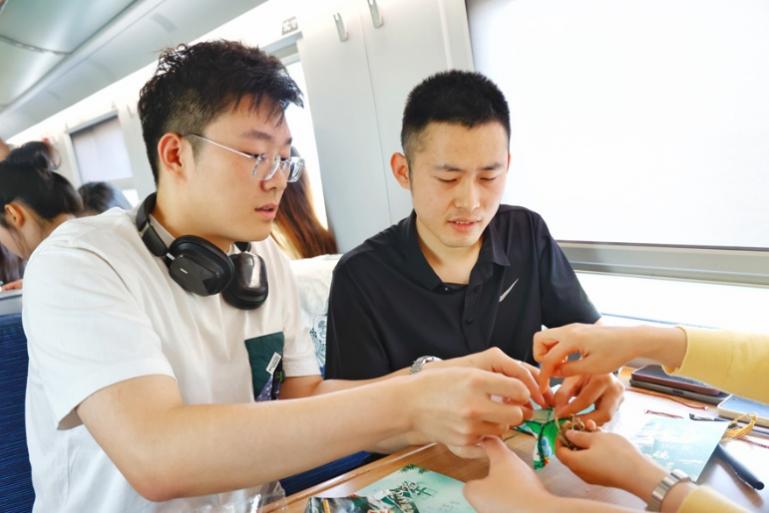 G232次旅客親手制作端午荷包和五彩繩。王磊攝